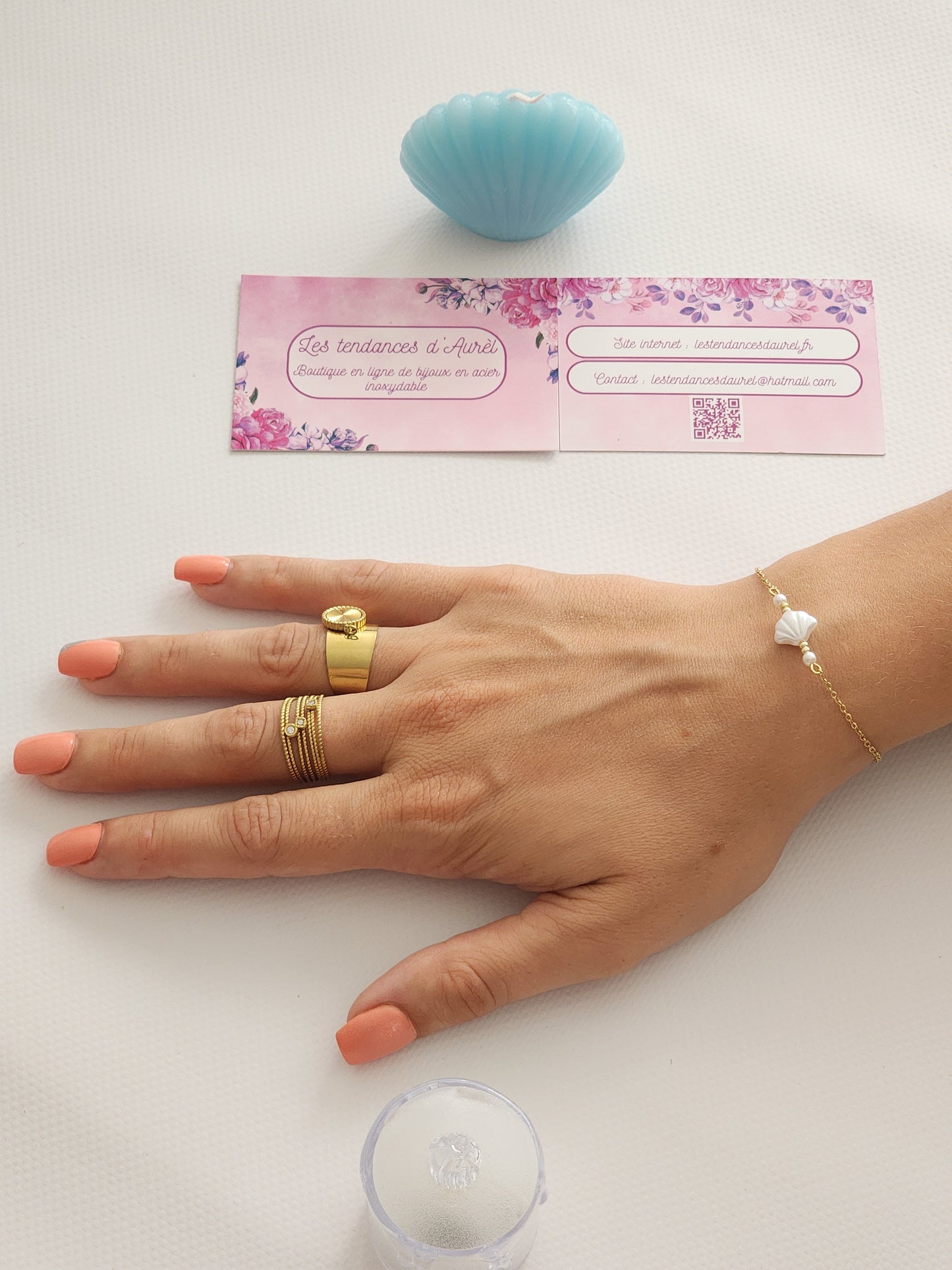 Bracelet Béa en acier inoxydable doré avec charm coquillage blanc, porté sur un poignet