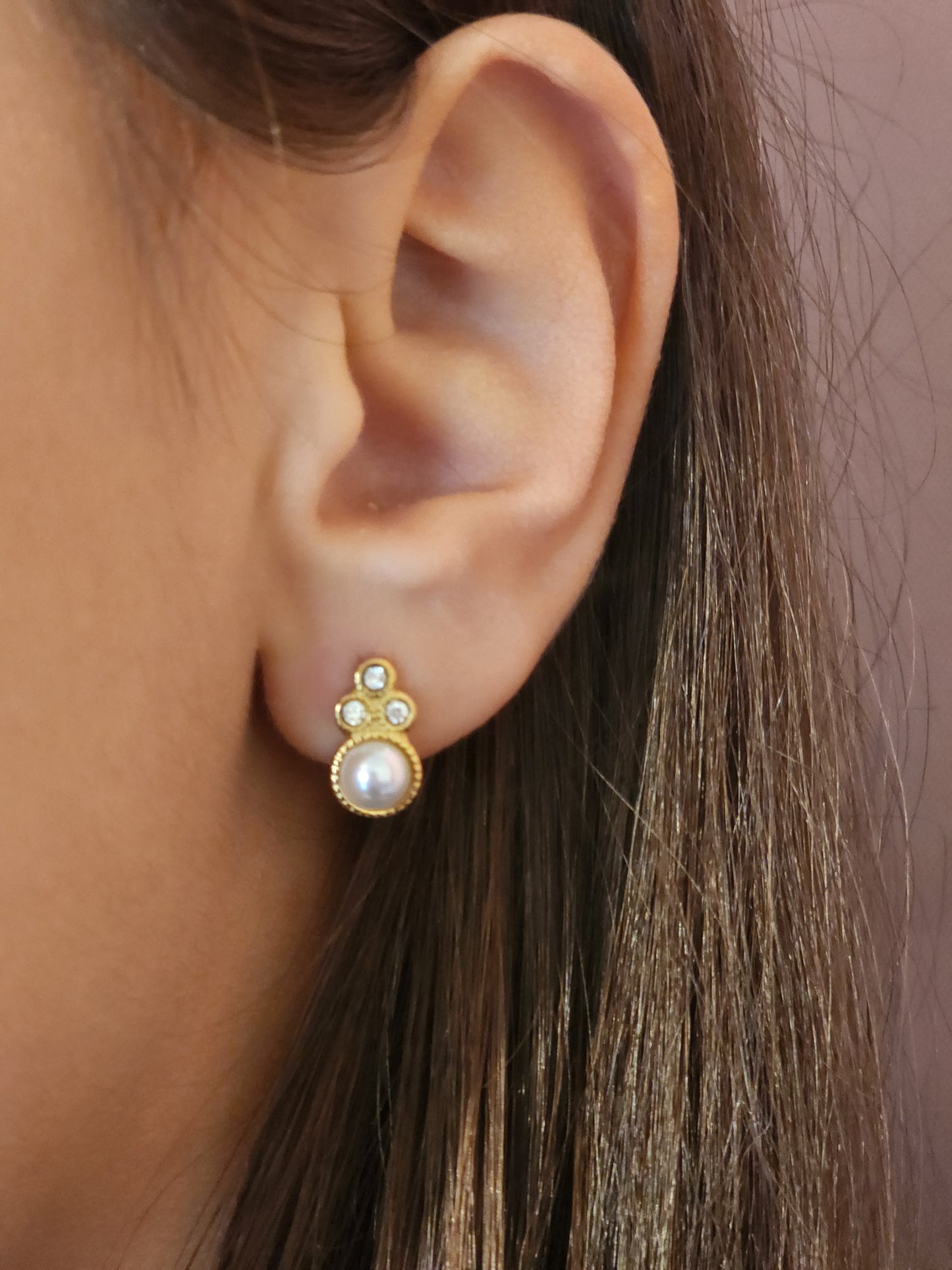 Boucles d'Oreilles Andréa en acier inoxydable doré avec strass brillants et perle élégante, portées sur une oreille