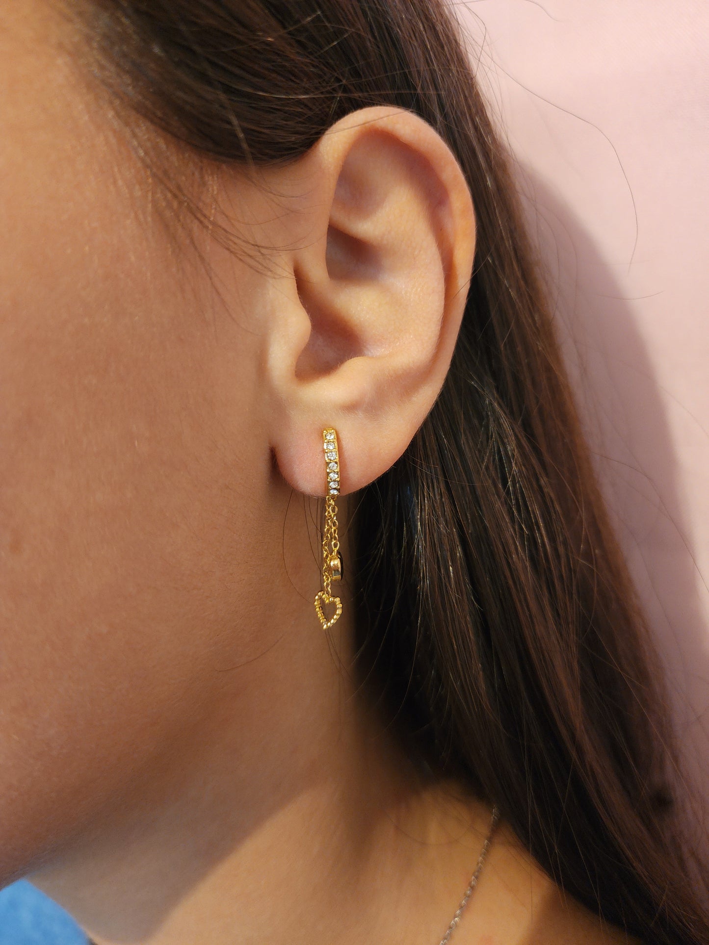 Boucles d'Oreilles Olivia en acier inoxydable doré avec cœur ajouré et chaînes délicates, portées sur une oreille