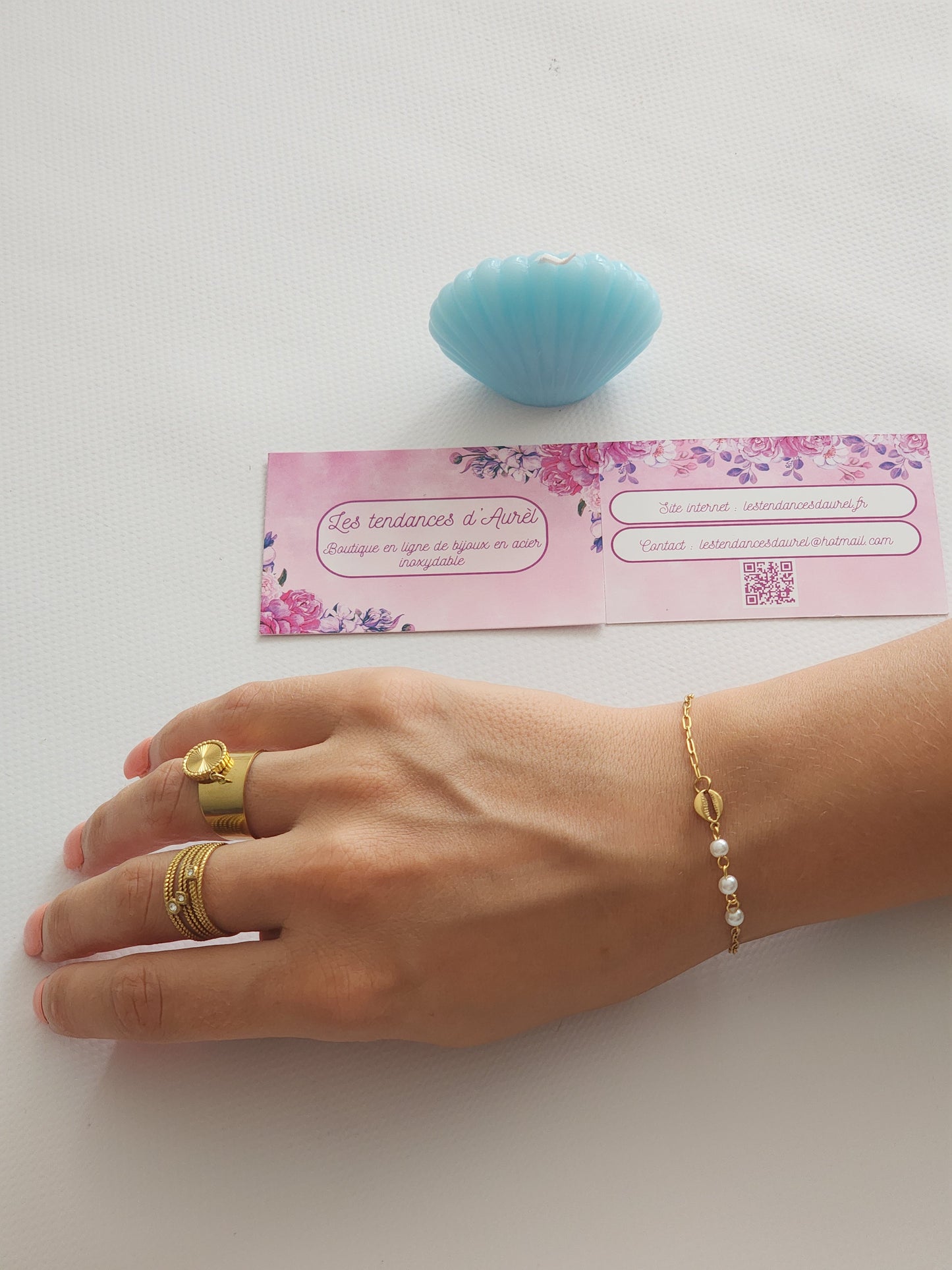 Bracelet Eva en acier inoxydable doré avec coquillage doré et perles blanches, porté sur un poignet.
