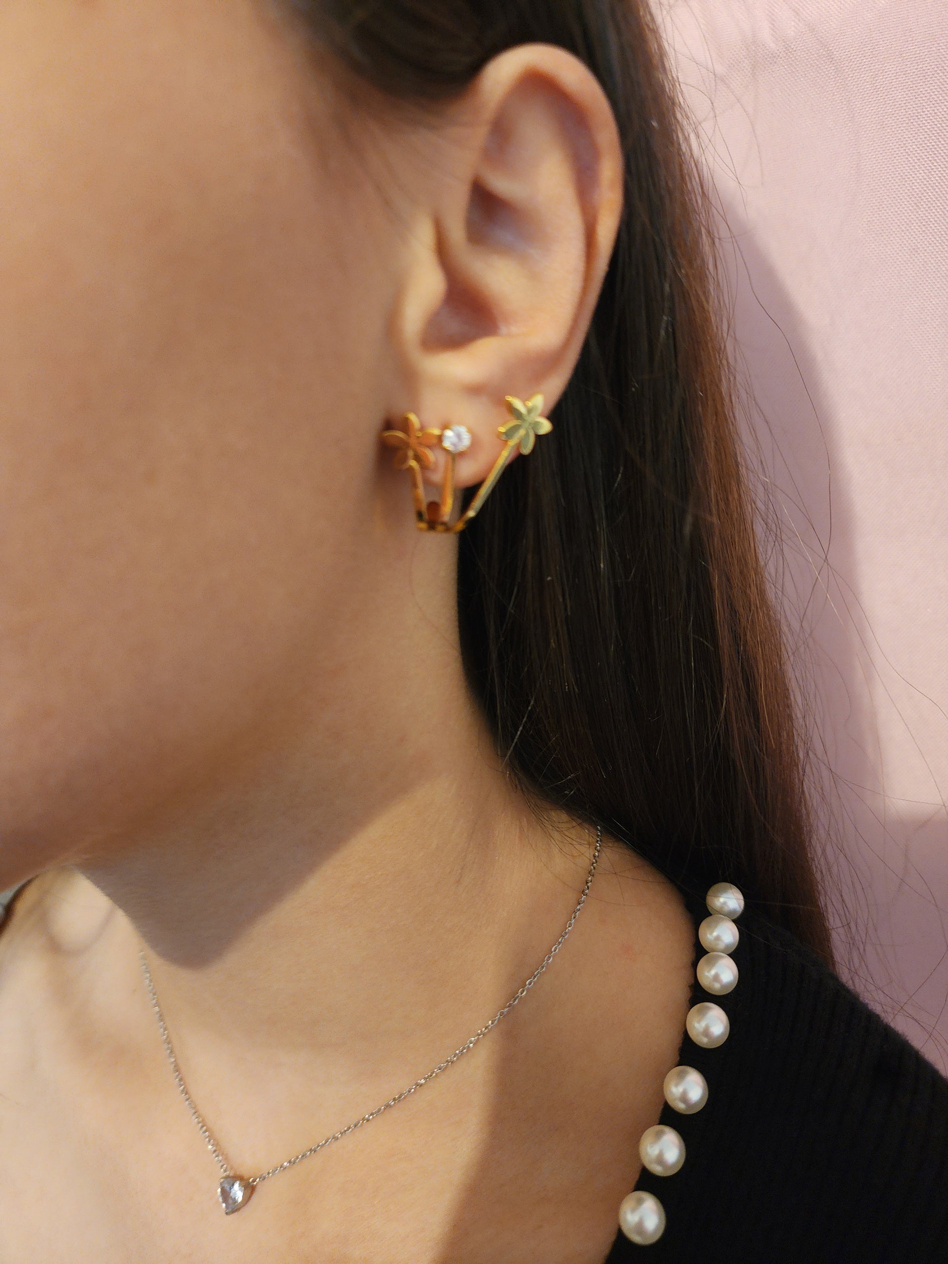 Boucles d'Oreilles Anita en acier inoxydable doré avec fleurs et strass étincelants, portées sur une oreille