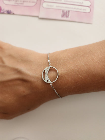 Bracelet Jacinda en acier inoxydable argenté avec cercle orné de strass, porté sur un poignet