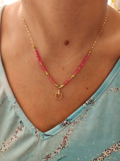 Collier Clara en acier inoxydable doré avec perles roses et pendentif incrusté de strass, porté sur un cou