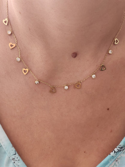 Collier Florentina en acier inoxydable doré avec cœurs ajourés et strass brillants, porté sur un cou