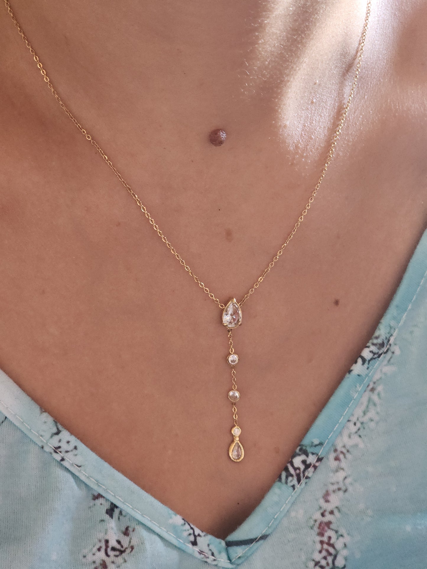 Collier Luciana en acier inoxydable doré avec pendentif goutte serti de zirconium, porté sur un cou.