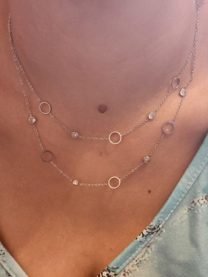 Collier Mélinda en acier inoxydable argenté à deux rangs avec cercles et strass, porté sur un cou