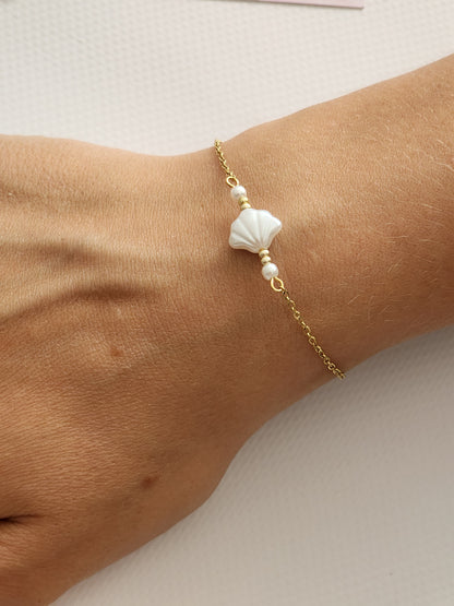 "Détail du charm en forme de coquillage blanc du Bracelet Béa en acier inoxydable doré