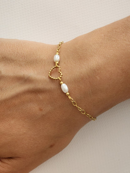 Détail du charm en forme de cœur doré et des perles blanches du Bracelet Lara en acier inoxydable